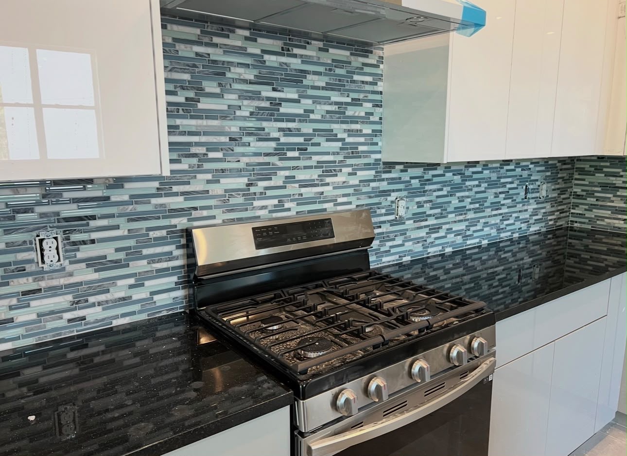 Blue, gray, and white mosaic backsplash in a kitchen