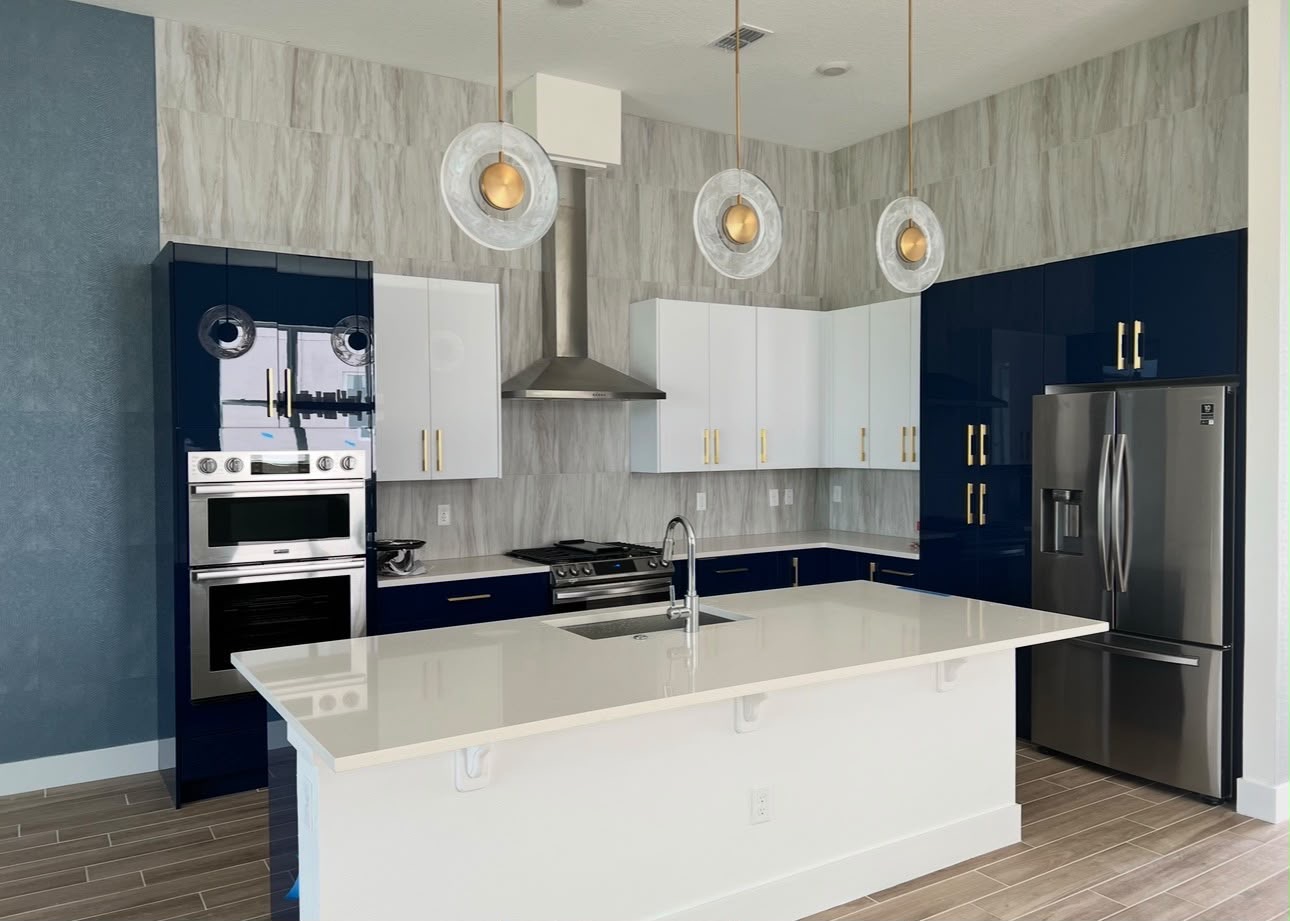 Kitchen with tiled floors and walls, blue and white cabinets, and a white island
